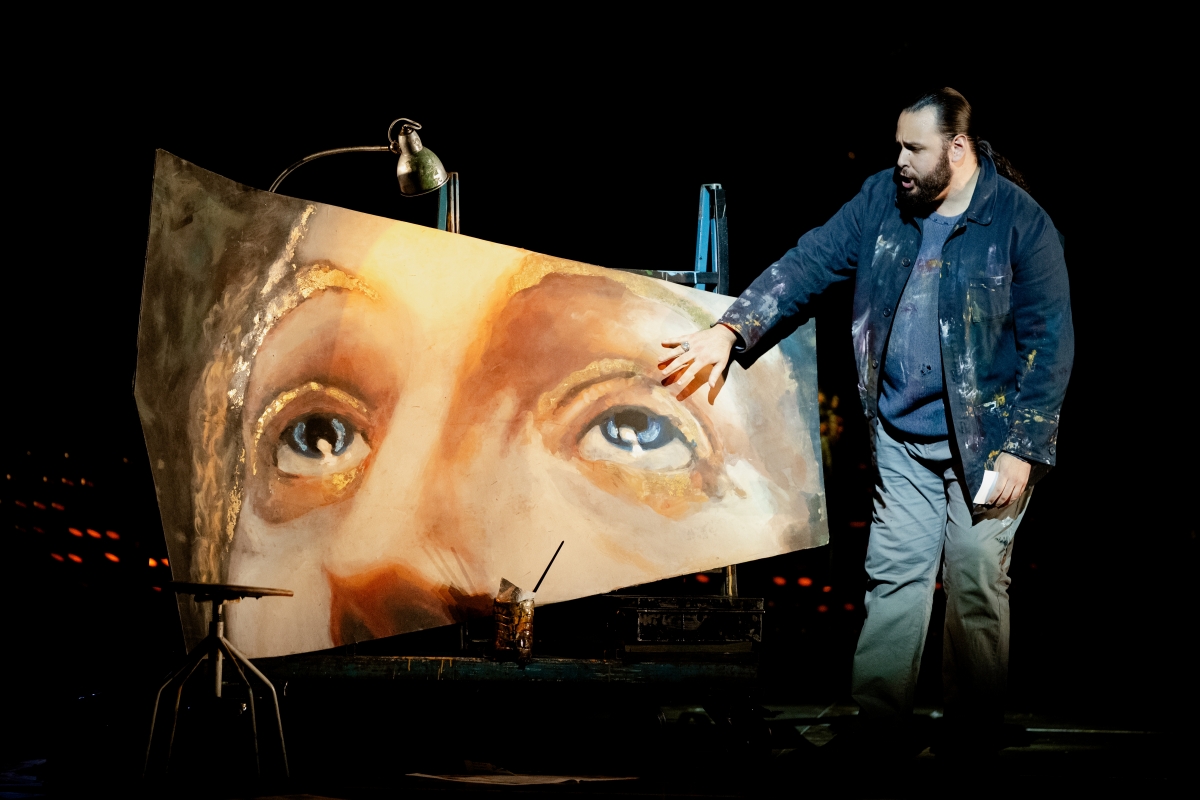 WNO Tosca Andrés Presno Cavaradossi Photo Credit Dafydd Owen 110 Cavaradossi stands to the right of his painted fresco, his hand hovering above Mary Magdalene's left eye. He wears a jacket splattered with paint.
