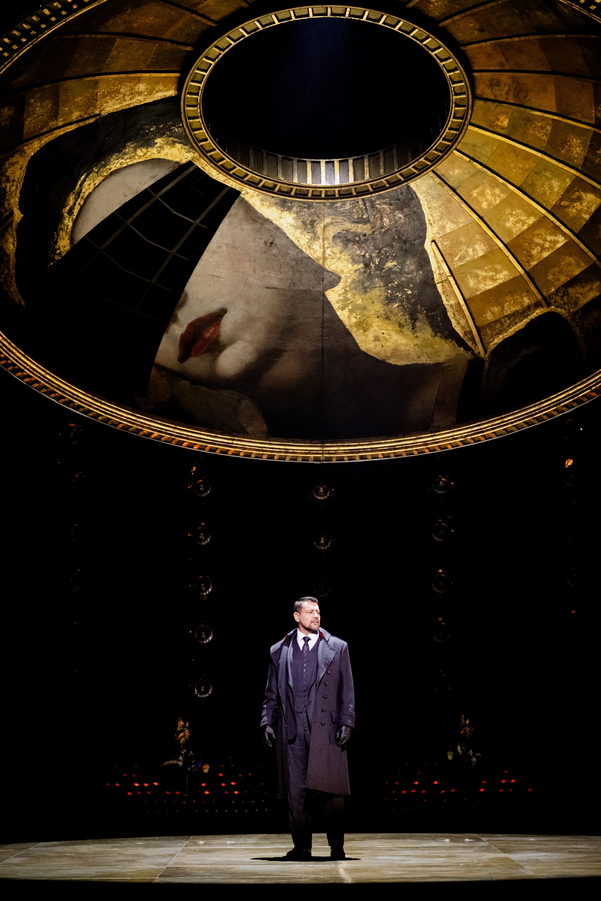 WNO Tosca Dario Solari Scarpia Photo Credit Dafydd Owen 677 Scarpia stands centre stage, wearing a suit, a formal jacket and leather gloves. The golden dome hangs above him, with one piece missing - the fresco featuring the eyes of Mary Magdalene.