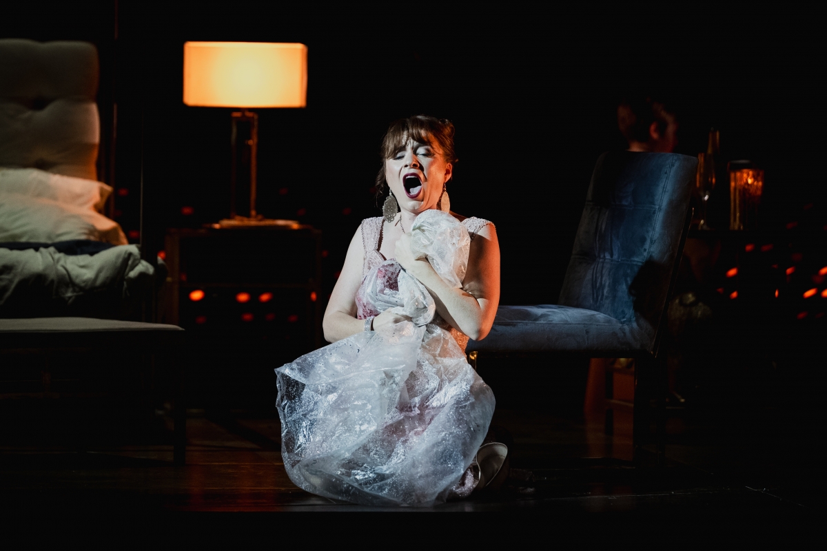 WNO Tosca Natalya Romaniw Tosca Photo Credit Dafydd Owen 1762 Tosca is on the floor of Scarpia's bedroom on her knees, singing passionately. She holds a large plastic sheet covered in blood close to her chest.