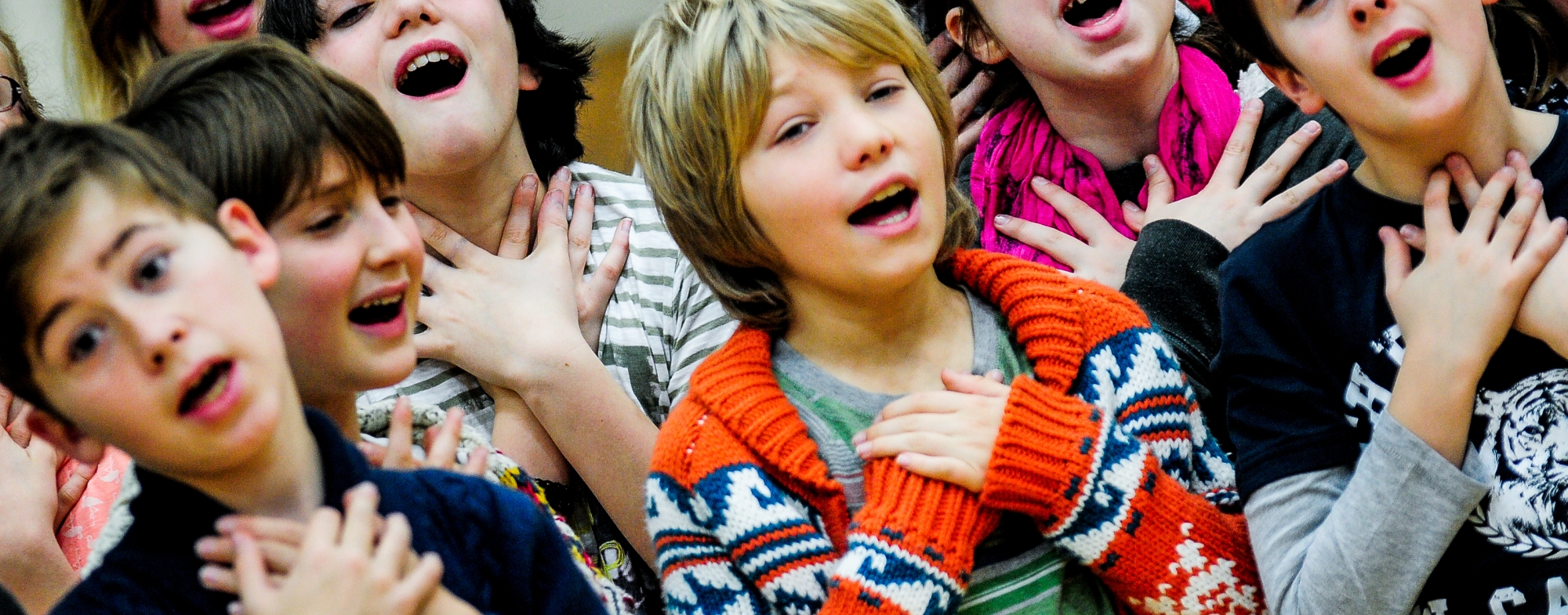 Wnyosingclubdec2013©Kirstenmcternan 138 1 Kirsten Mcternan 2013 A group of children are singing emotively.