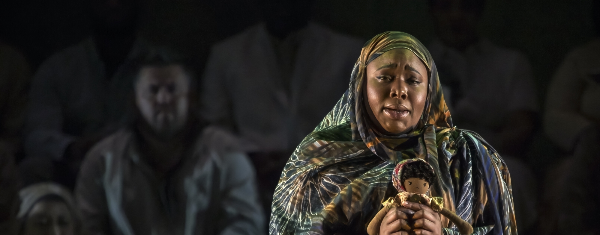 WNO Migrations The English Lesson Brittany Olivia Logan Emelda photo credit Craig Fuller Woman dressed in a shawl holds a doll in her hands