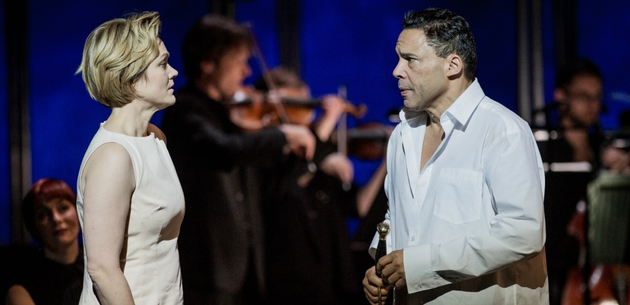 Le Vin Herbe 2017 Robert Workman 2017 Cymraeg: Female and male performer on stage in a heartfelt exchange, orchestra out of focus in the background