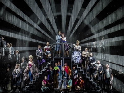 A group of people stand on two sets of stairs, with light radiating from them in a circle