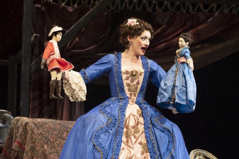 WNO The Barber of Seville Heather Lowe Rosina photo credit Richard Hubert Smith 4803 Rosina holding up two dolls in each hand